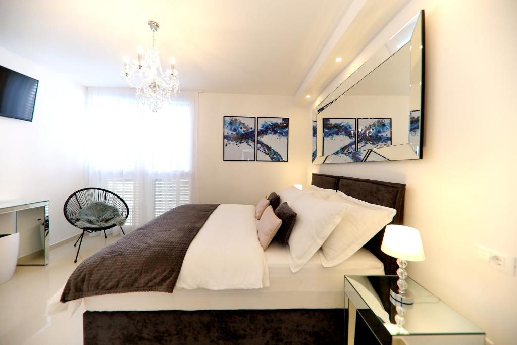 扎达尔KIKO Luxury Accommodation的一间卧室配有一张床、一张书桌和一面镜子