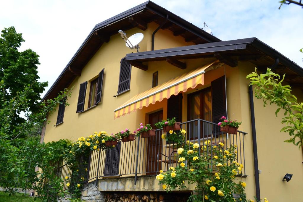 里韦尔加罗曼德罗拉农庄民宿的阳台黄色房子,鲜花盛开
