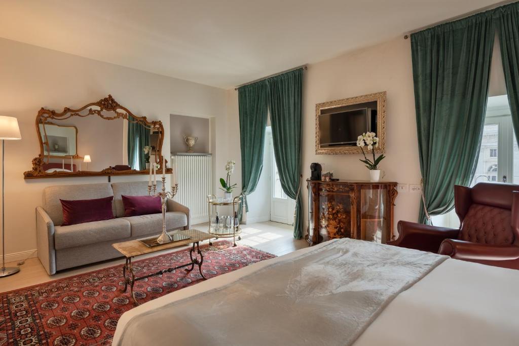 都灵Corte Realdi Luxury Rooms Torino的一间卧室配有一张床、一张沙发和一面镜子
