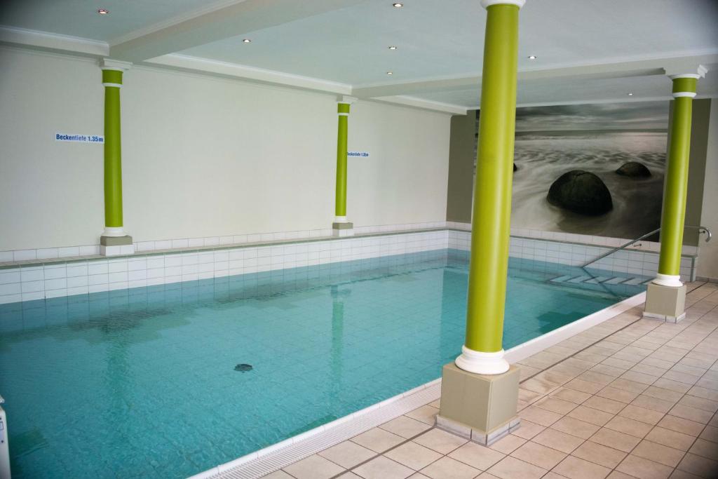 凯沃拉尔凯沃拉尔花园酒店的一座建筑物内带有绿色柱子的游泳池