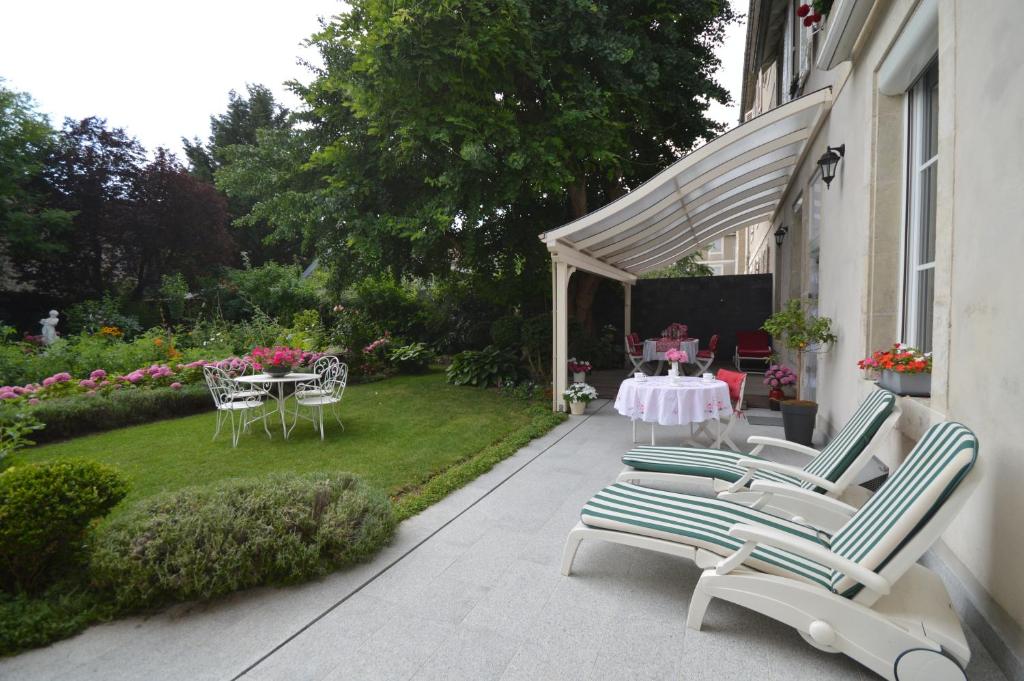 图勒Chambre d'hôtes à TOUL centre ville avec parking privé的一个带桌椅的庭院和一个花园