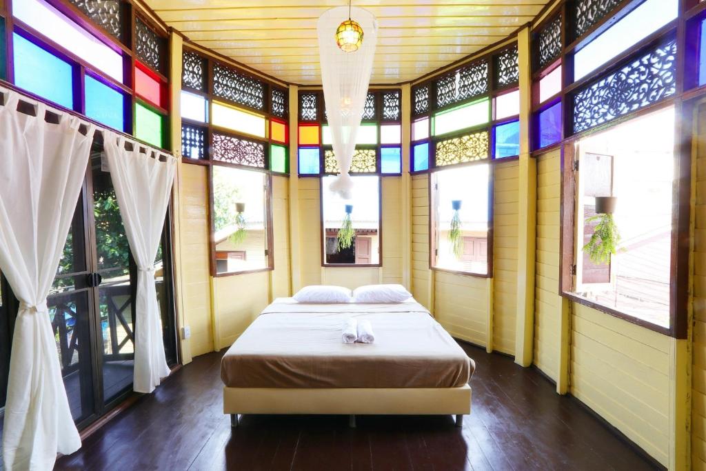 曼谷Baankhon Private room in Thai house Adult only Check in by yourself的一间设有床铺的卧室,位于带窗户的房间内