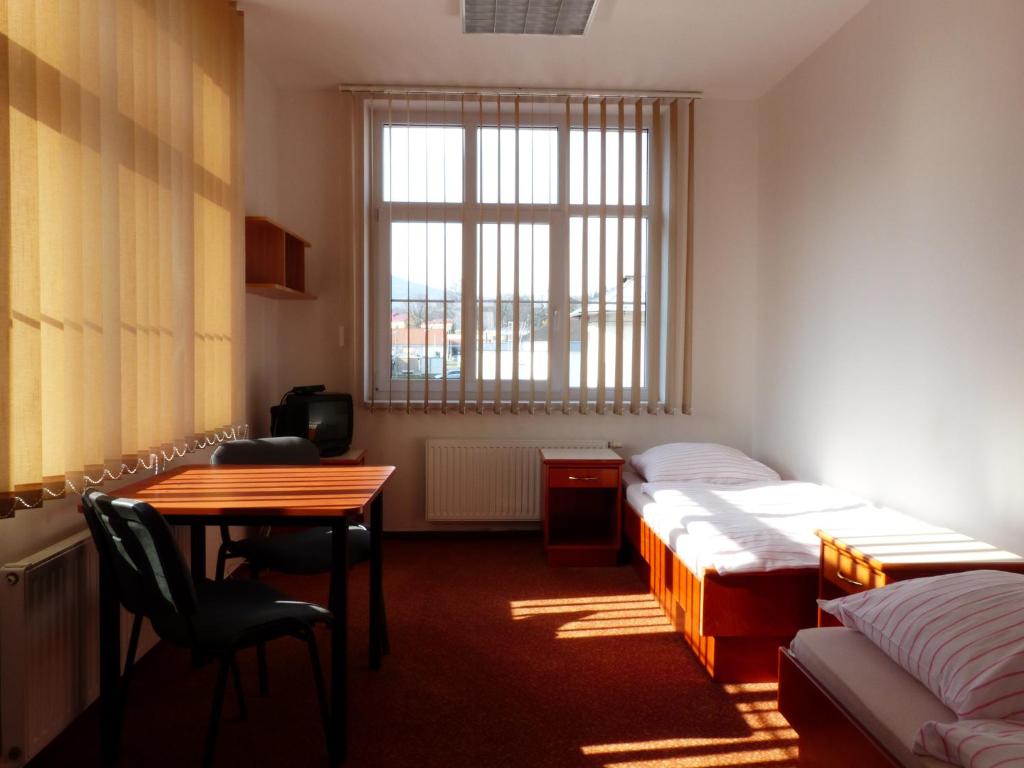 弗尔赫拉比Ubytovani Rico的客房设有两张床、一张桌子和一张书桌。