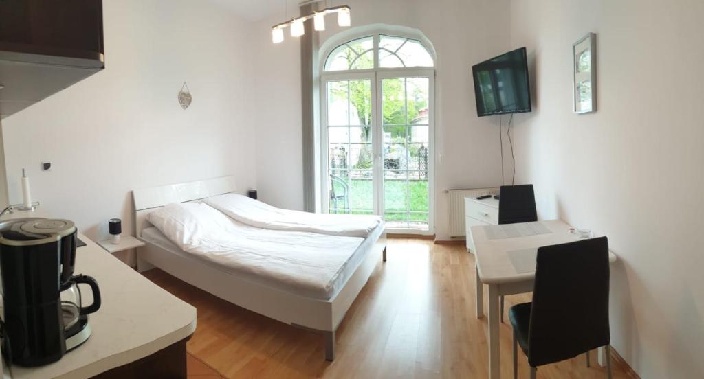 斯维诺乌伊希切Apartament Trzy Korony 1的一间卧室配有一张床、一张桌子和一个窗户。
