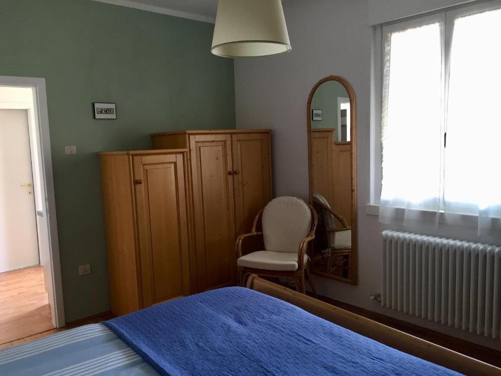卡尔多纳佐Appartamento Guccio的一间卧室配有一张床、镜子和椅子