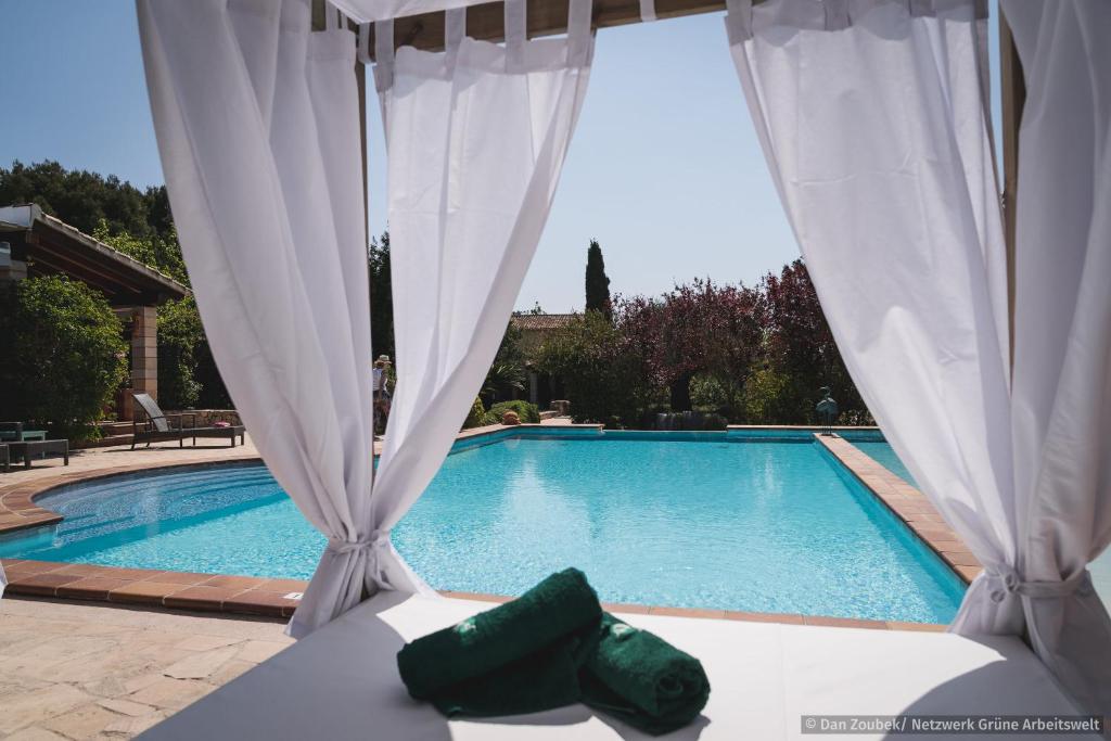 克里斯托港萨瓦科里亚度假屋的享有游泳池的景致,配有白色窗帘