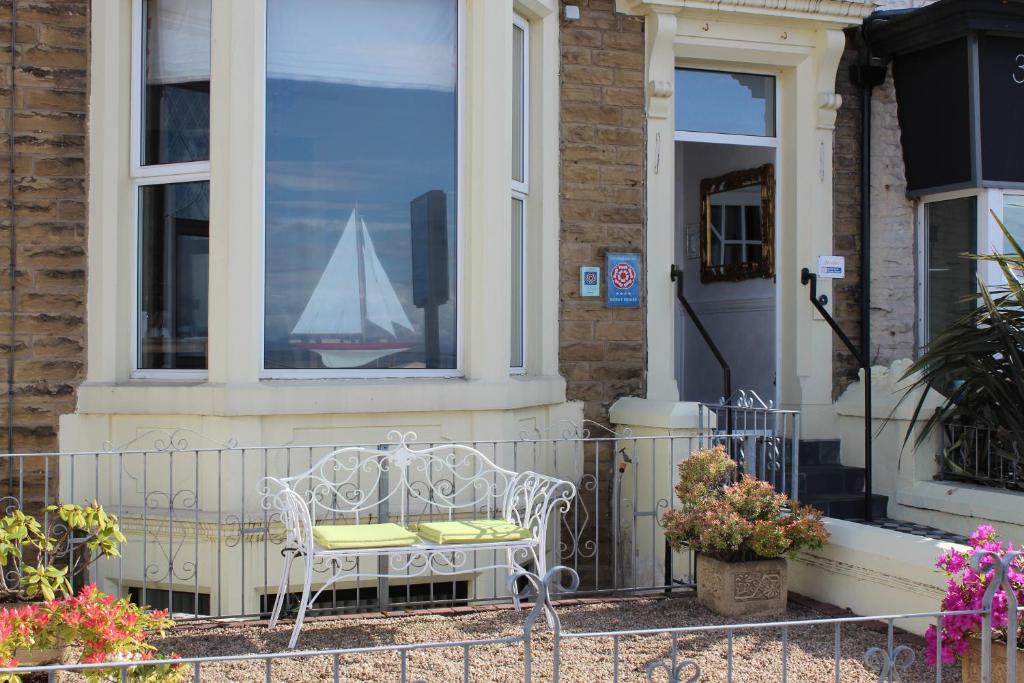 莫克姆阿什利酒店的靠窗的帆船坐在房子外的白色椅子