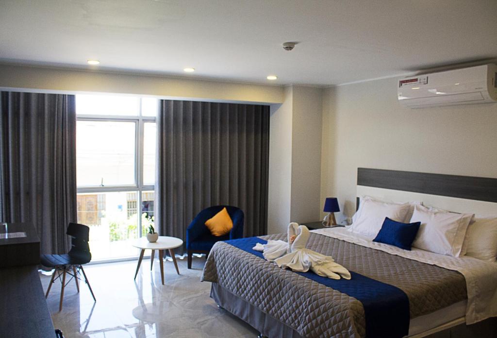 塔拉波托Palm Hotel Tarapoto的酒店客房设有一张床和一个大窗户