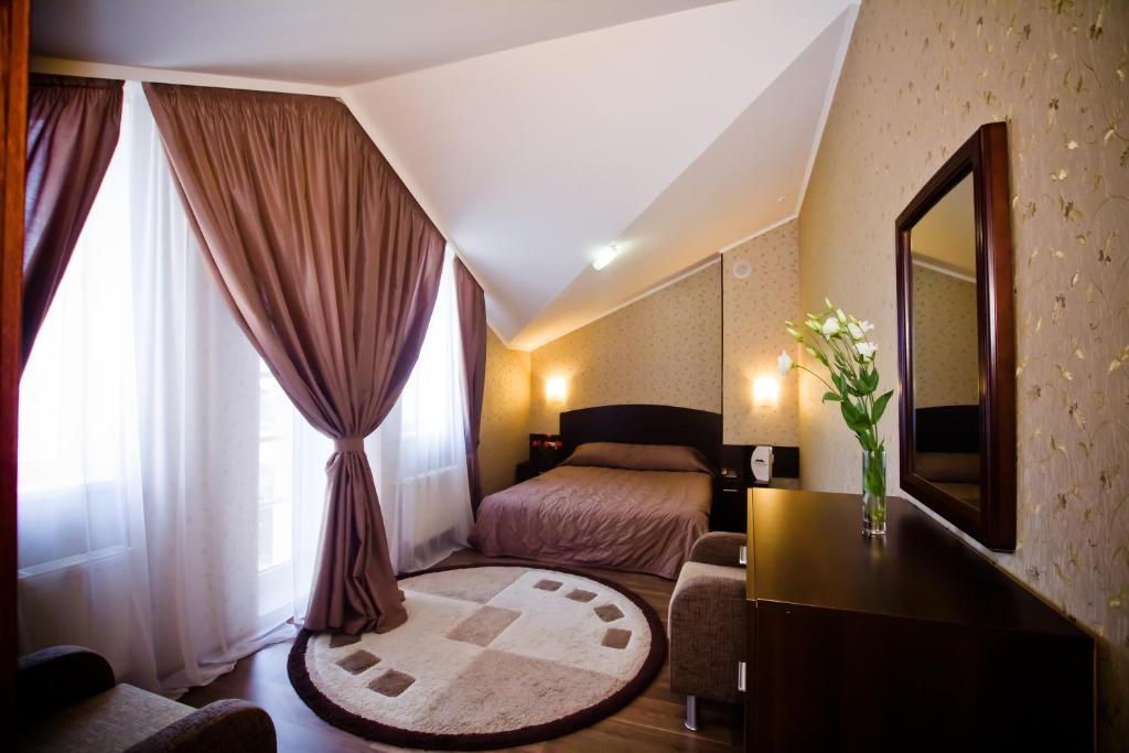 哈尔科夫城市俱乐部酒店的酒店客房,配有床和镜子