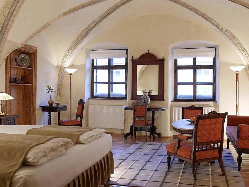 锡吉什瓦拉福尼斯精品旅馆的卧室配有一张床和一张桌子及椅子