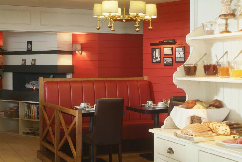 德哈恩因特诺斯酒店的餐厅拥有红色的墙壁,配有一张带食物的桌子。