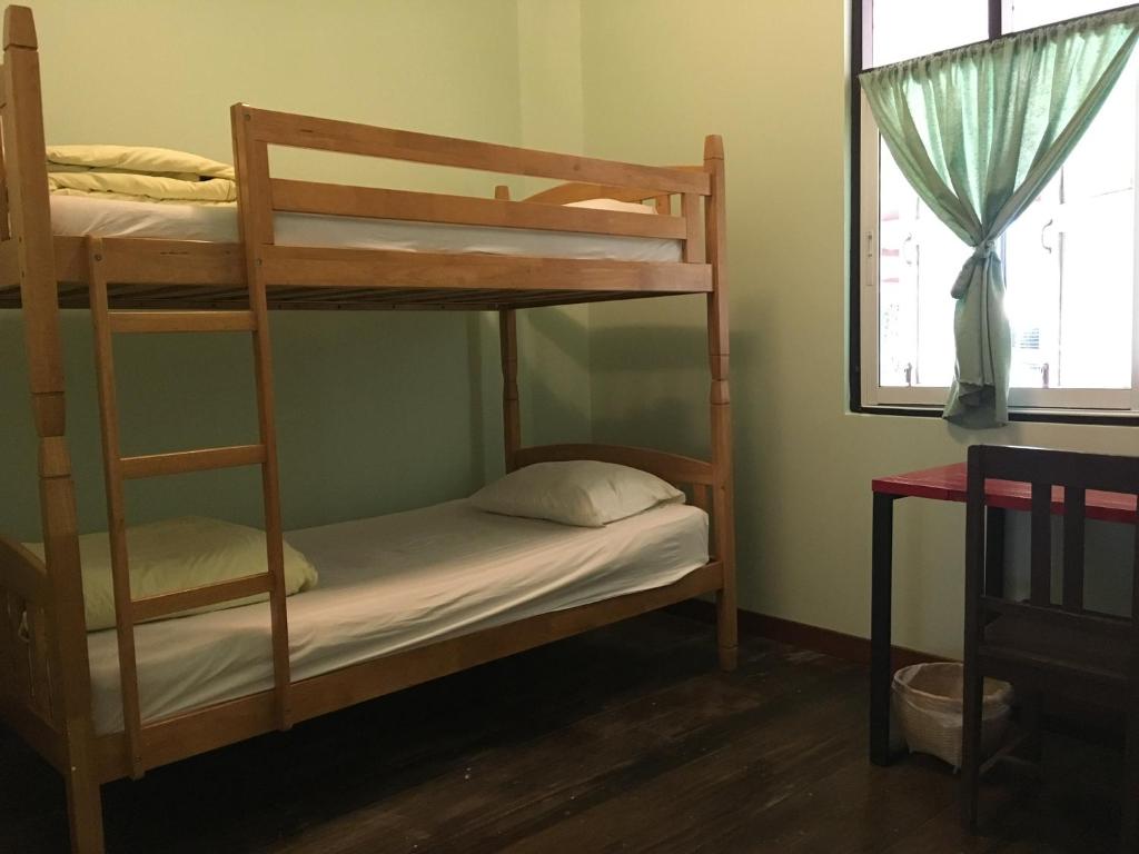 清莱班布华宾馆的一间卧室设有两张双层床和一扇窗户。