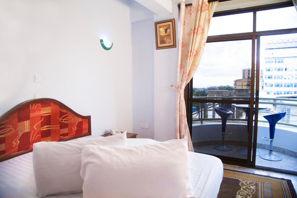 阿鲁沙纳特龙宫宾馆的一间卧室设有两张床和大窗户