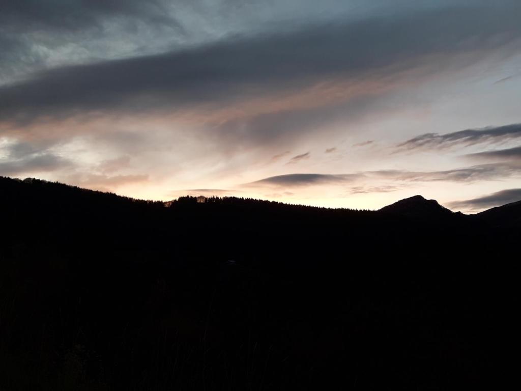 PradaResidenza il bosco的山丘的轮廓,背景是日落