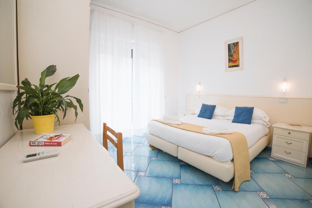 马奥莱德罗莎酒店的一间卧室配有一张床和一张植物桌子