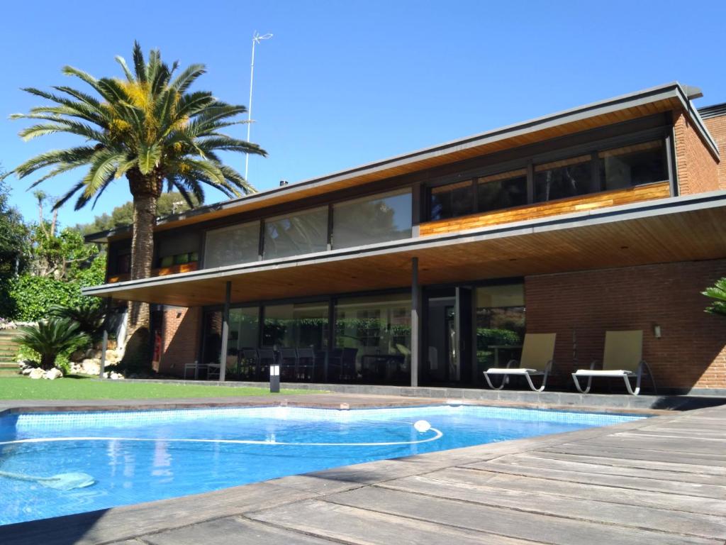 卡斯特尔德费尔斯VILLA DEL BOSQUE的一座房子前面设有游泳池