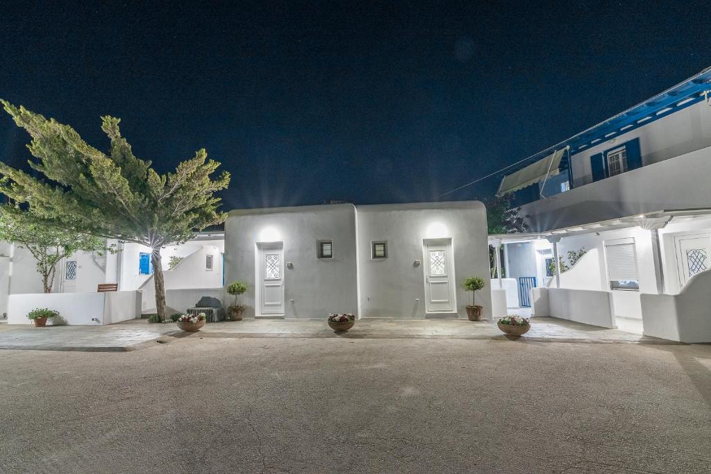 克洛瓦斯米科诺斯岛弗洛拉公寓的白色的建筑,有白色的门和棕榈树