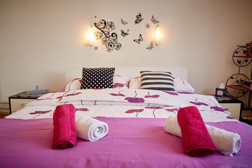 图兹拉Central Tuzla apt - free parking的一间卧室配有带粉红色毛巾的床