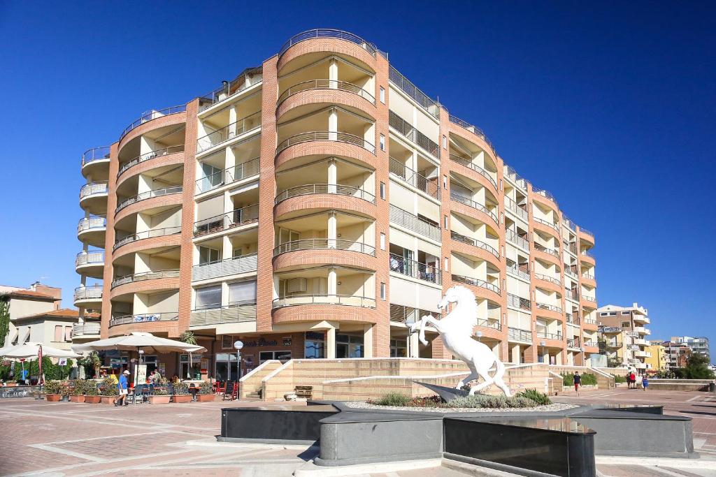 格罗塞托港地中海公寓酒店的一座大建筑,前面有雕像