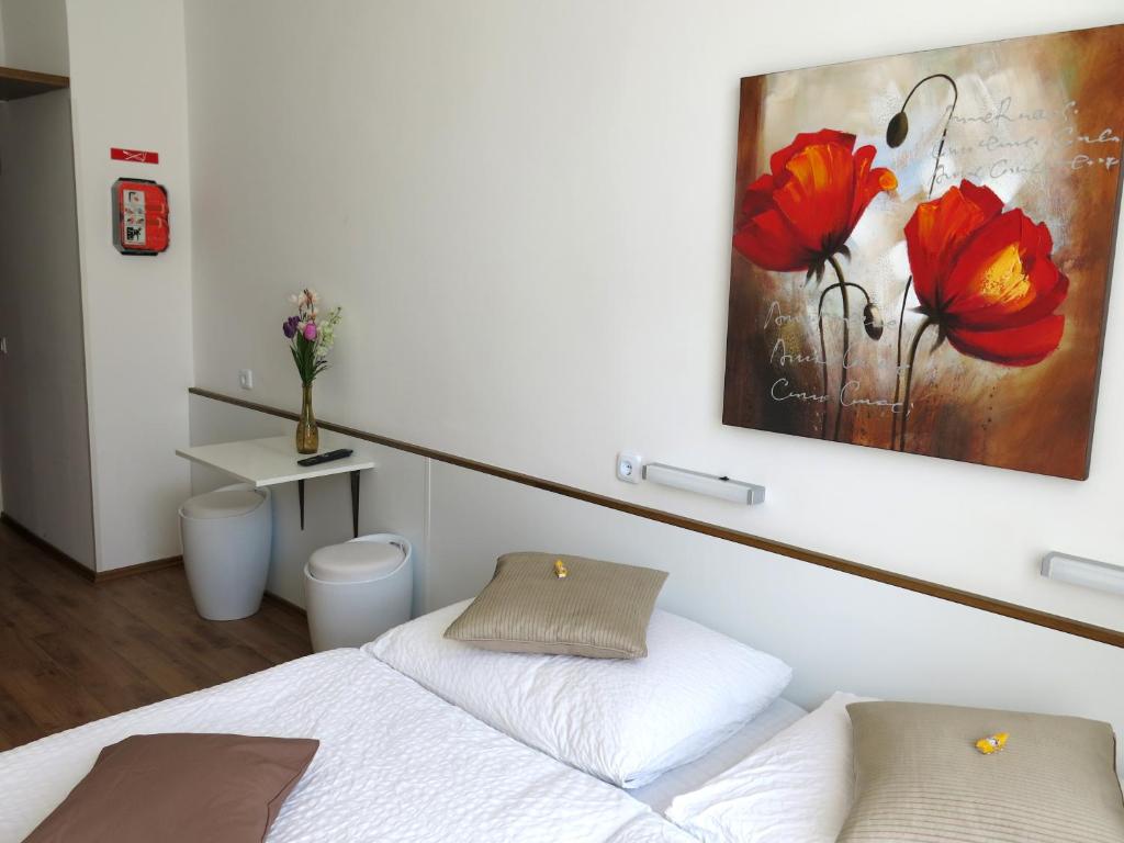 维也纳KIBI Rooms self check-in的卧室配有一张床,墙上挂有绘画作品