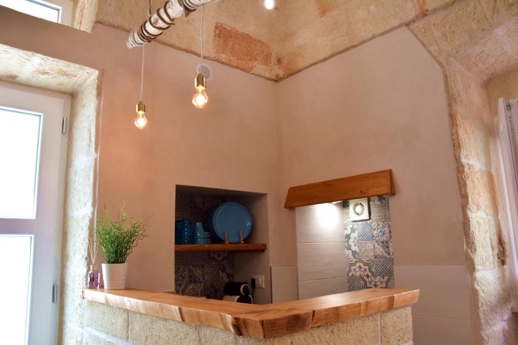 莫诺波利Casa vacanze "La Maison Du Bonheur"的浴室设有一面镜子和石墙