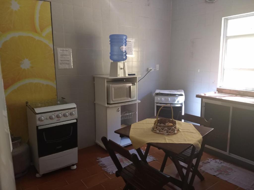 伊利亚孔普里达Hostel Beira Mar的厨房配有桌椅和微波炉。