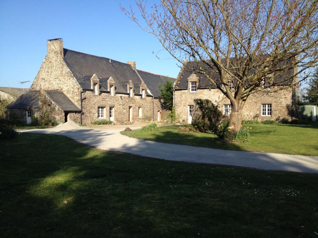 圣库隆Maison d'hôtes "Bienlivien"的一座大石头房子,前面有一棵树