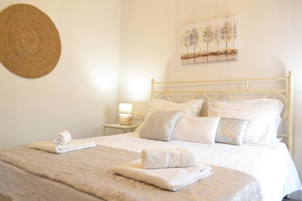 纳克索乔拉Ariadne & Theseus Apartments的卧室配有白色的床和2条毛巾