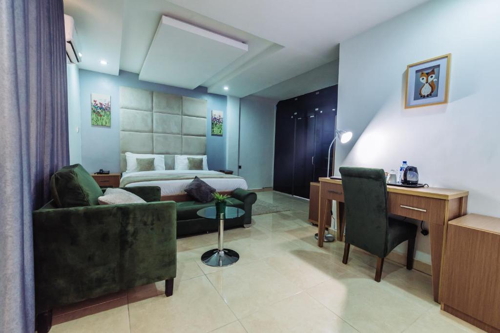 阿布贾宁静缪斯酒店 的酒店客房,配有一张床、一张桌子和椅子