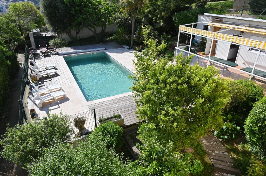 滨海拉塞讷Villa Eveil的享有带椅子和树木的游泳池的顶部景致