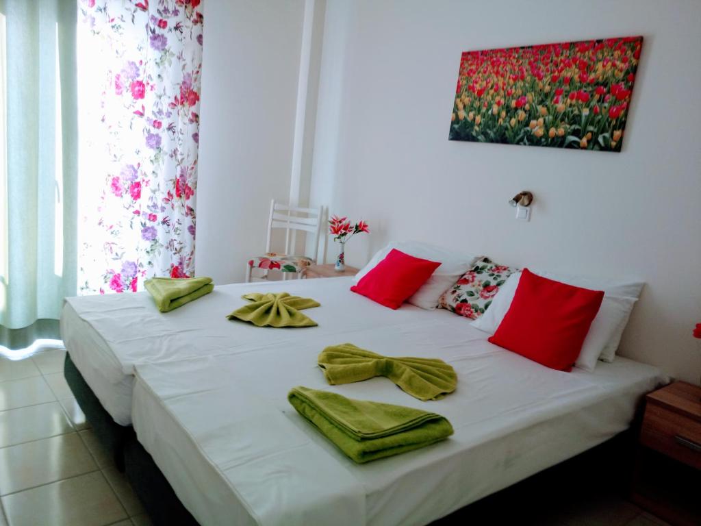 帕罗奇亚梅莱蒂斯公寓酒店的一间卧室配有一张带红色和绿色毛巾的床