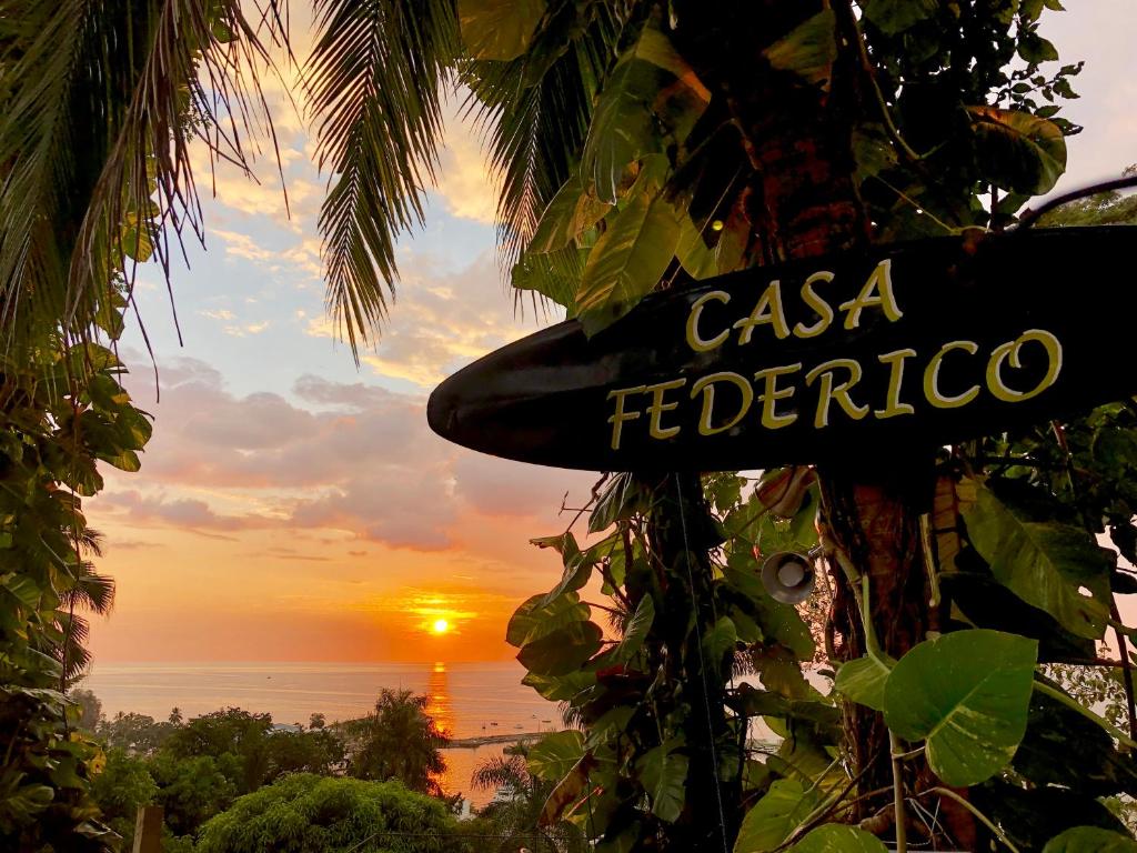奎波斯城Casa Federico的树上的一个标志,背景是日落