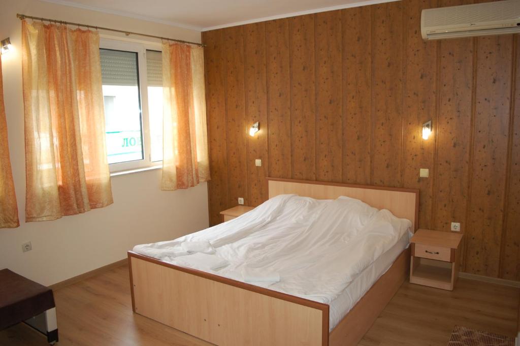 特里亚夫纳Hotel Vitosha的一间卧室配有一张带白色床单的床和一扇窗户。