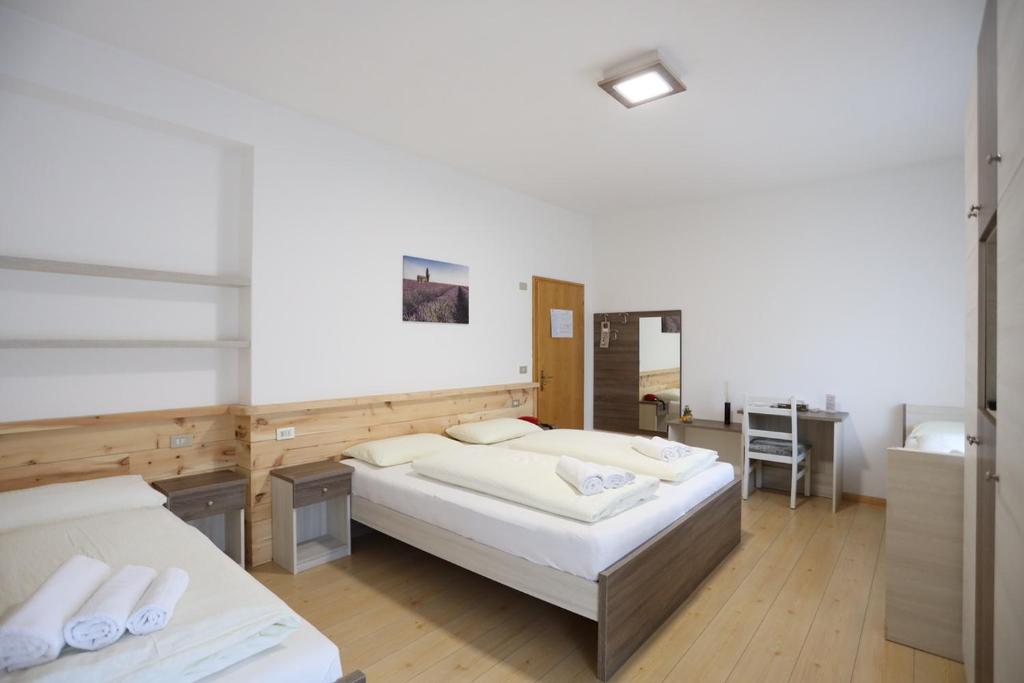 卡拉诺艾尔伯格贝拉利雅酒店的大房间设有两张床和一张书桌