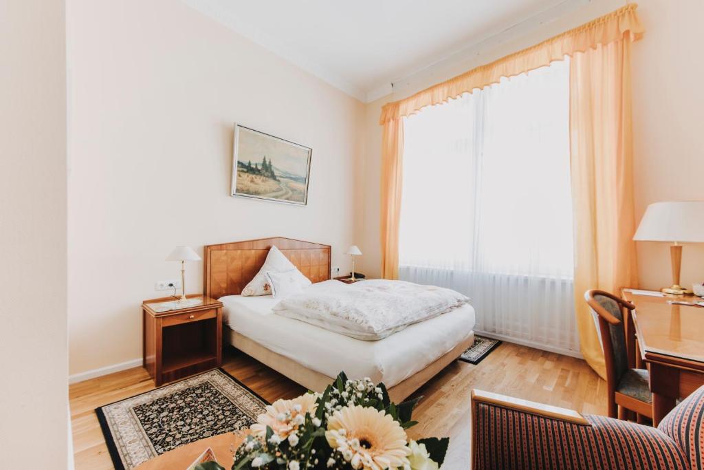 巴特瑙海姆斯浦特尔酒店的一间卧室配有一张床、一张书桌和一个窗户。