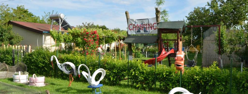 克里尚Camping Casuta Mihaela的庭院,草地上设有天鹅雕塑的游乐场