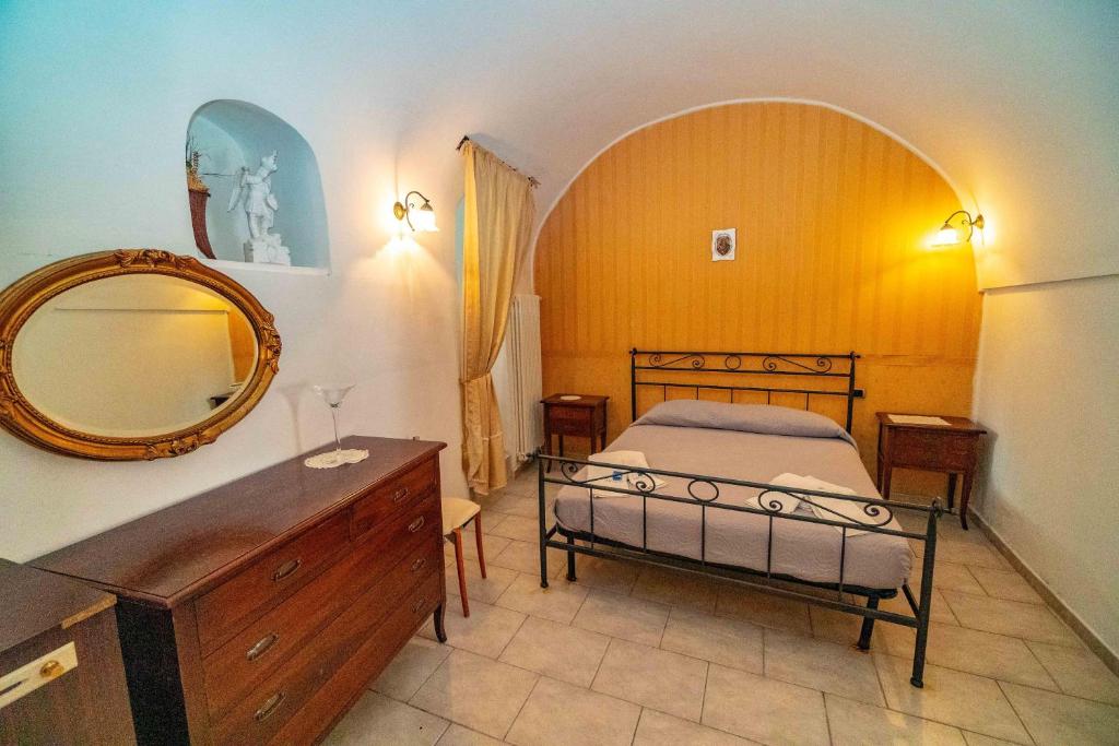 圣安吉罗山Caratteristica casa in piazzetta的一间卧室配有床、镜子和梳妆台