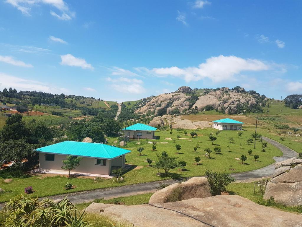 埃祖尔韦尼Mdzimba Mountain Lodge的享有山丘上带房屋的农场的空中景致