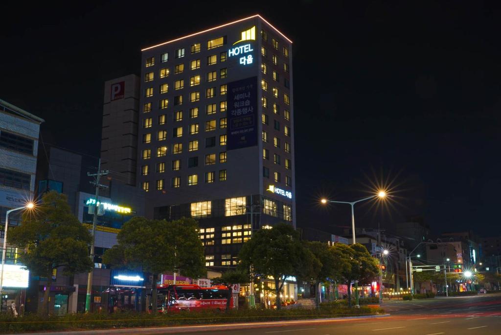 蔚山Hotel Daoom的一座高大的建筑,晚上有灯