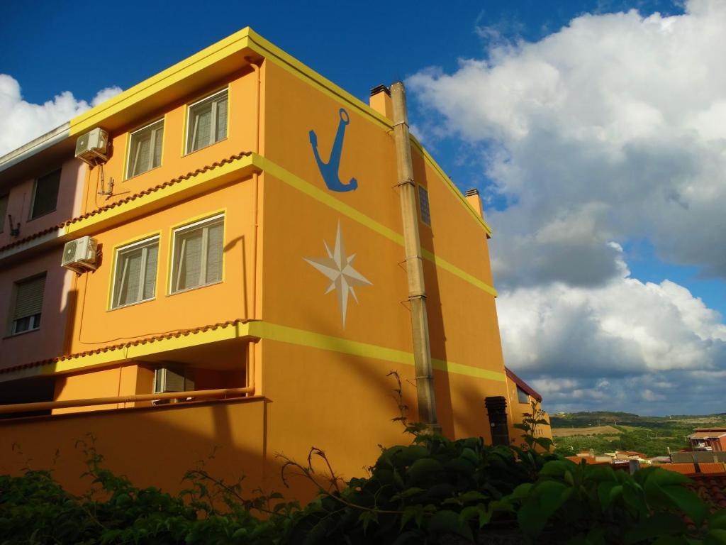 贡内萨Appartamento La Collinetta的黄色的建筑,旁边标有标志