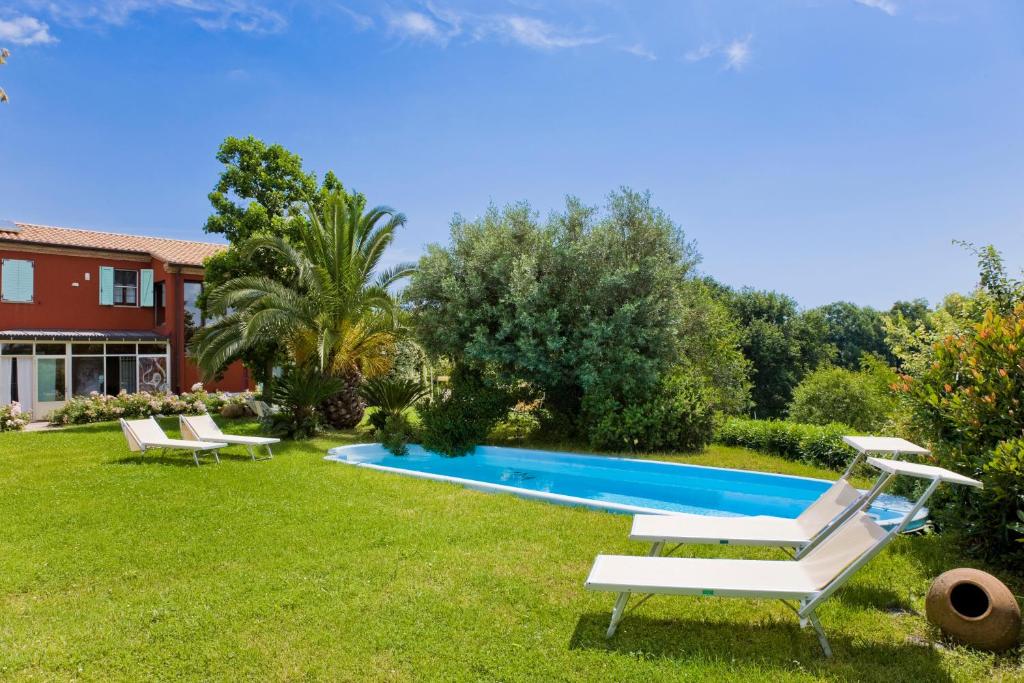 锡罗洛Borgo Rosso Country House B&B的一个带2把躺椅的庭院内的游泳池