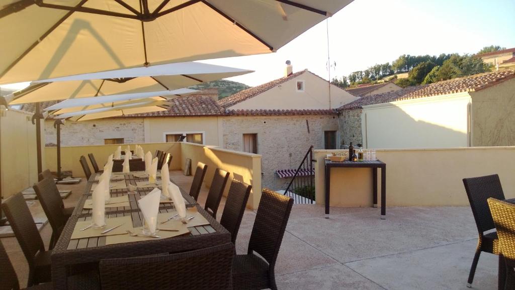 AlesAbas Ristorante Pizzeria Affittacamere的庭院里配有桌椅和遮阳伞