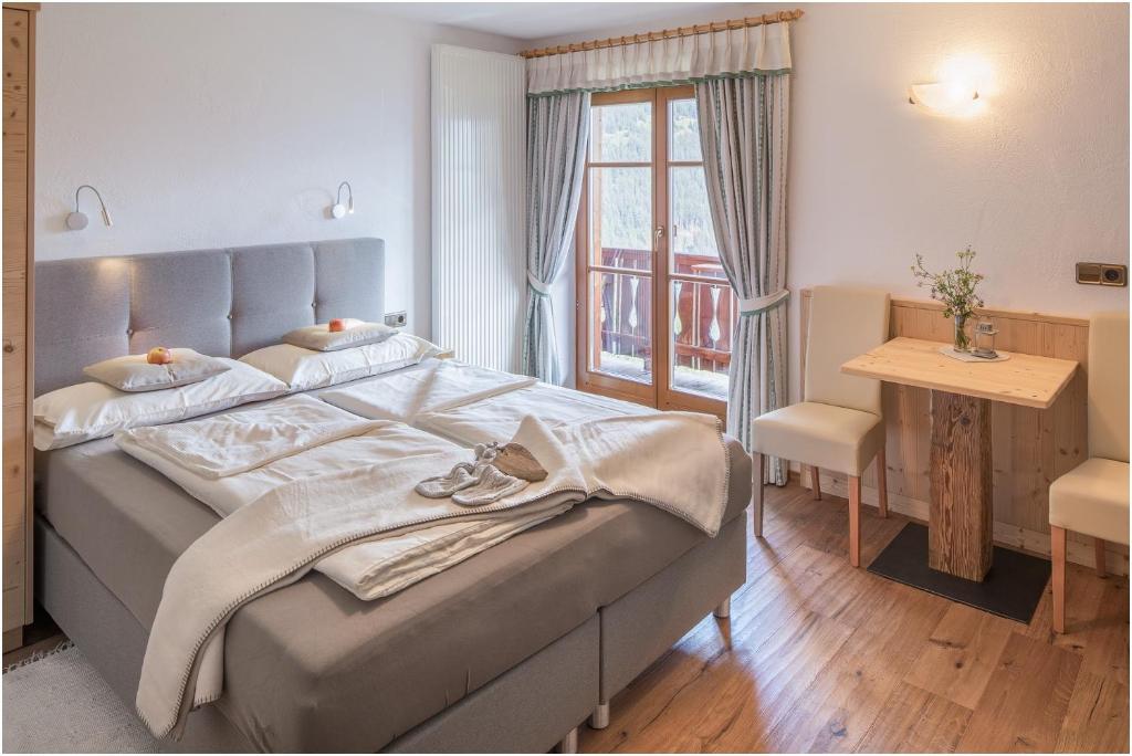 多比亚科Nigglerhof的一间卧室配有一张床、一张桌子和一个窗户。