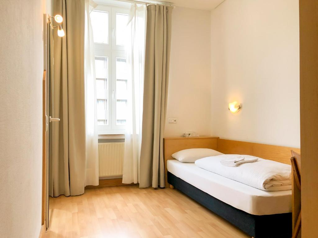 杜塞尔多夫月亮酒店的一张位于带大窗户的房间内的床铺