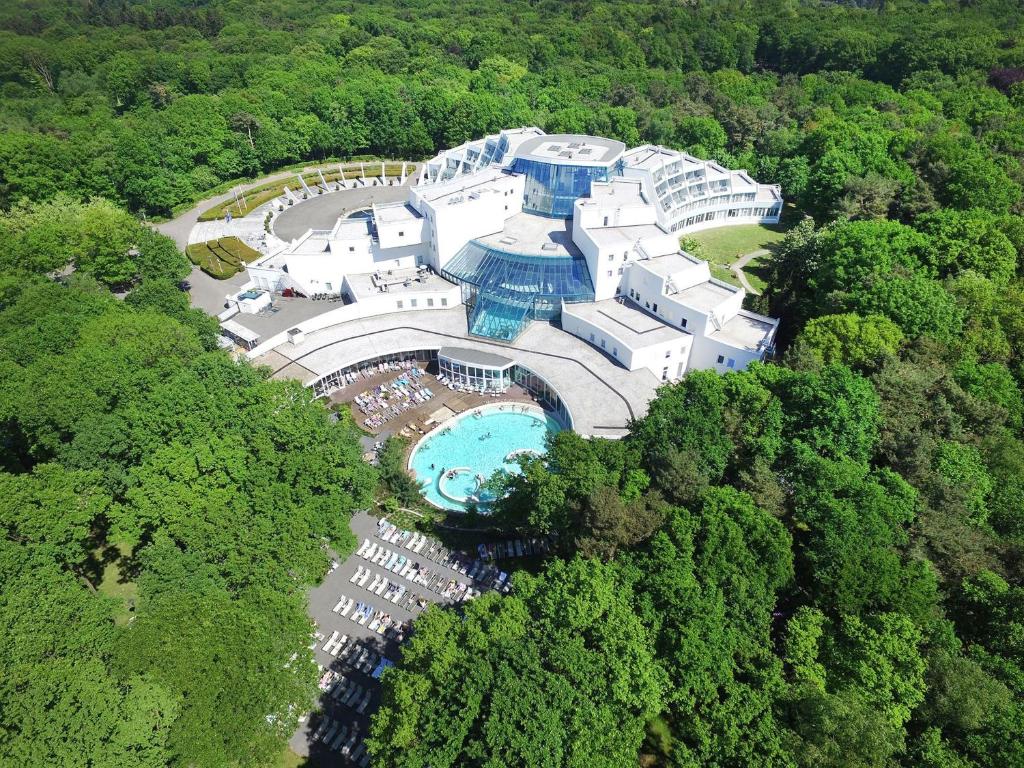 奈梅亨Sanadome Hotel & Spa Nijmegen的享有带游泳池的建筑的空中景致