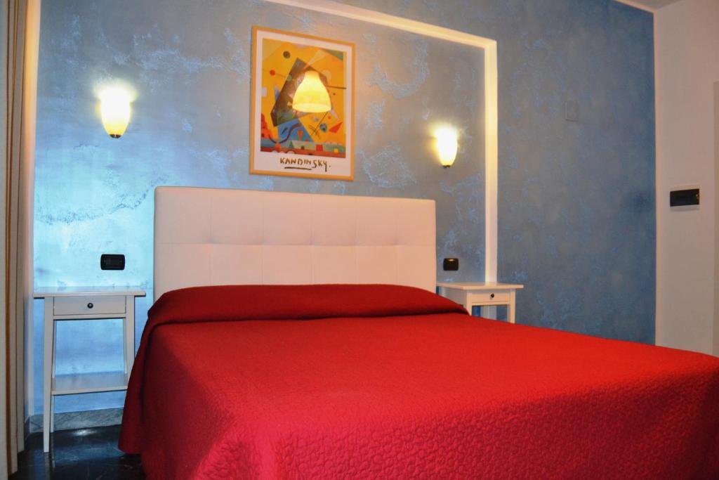 庞贝戴安娜住宿酒店的一间卧室配有红色的床和两张桌子