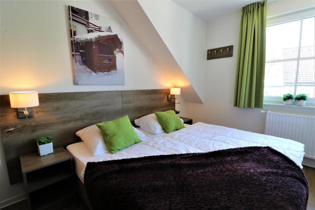 温特贝格UplandParcs Residence Astenberg的一间卧室配有一张带绿色枕头的大床