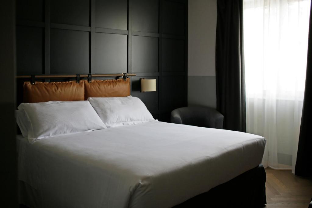 罗马罗马俱乐部会所c酒店的卧室设有一张白色大床和一扇窗户。