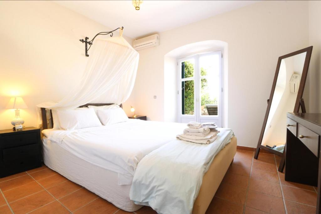Áyios PandeleḯmonThe Olive Press Villa的卧室配有白色的床和窗户。
