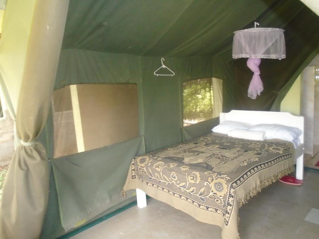 Ololaimutiek犀牛旅游营地旅馆的绿色帐篷内一间卧室,配有一张床